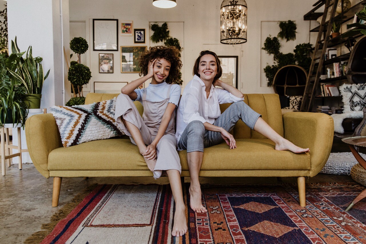 Two young women relaxing on a yellow couch 2026 03 18 12 10 44 utc groot